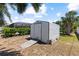 Backyard storage shed surrounded by lush landscaping and trees at 11153 Deerwood Ave, Englewood, FL 34224