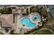 This aerial view showcases a swimming pool area with lounge chairs and well-manicured landscaping at 115 Babbling Brook Run, Bradenton, FL 34212