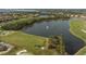 Aerial view of a golf course with water feature and sand traps, surrounded by lush landscaping at 115 Babbling Brook Run, Bradenton, FL 34212