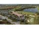 An aerial view captures the community clubhouse, golf course, tennis courts, pool and the surrounding neighborhood at 115 Babbling Brook Run, Bradenton, FL 34212