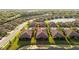 Aerial view of a home with a tile roof, lush landscaping, and proximity to a lake at 115 Babbling Brook Run, Bradenton, FL 34212