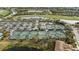 This aerial view shows the tennis courts with parking, golf course and community in the background at 115 Babbling Brook Run, Bradenton, FL 34212