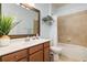 Well-lit bathroom featuring wood vanity, ample storage, and tiled tub and shower at 115 Babbling Brook Run, Bradenton, FL 34212
