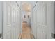 Hallway view to the ensuite bathroom featuring double closets and modern lighting at 115 Babbling Brook Run, Bradenton, FL 34212