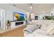 Spacious living room with large TV, fireplace, ceiling fan, and open floor plan to the kitchen and dining areas at 115 Babbling Brook Run, Bradenton, FL 34212