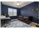 Comfortable office space featuring a leather couch, blue accent wall, and natural light at 115 Babbling Brook Run, Bradenton, FL 34212