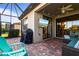 Outdoor patio area featuring brick flooring, seating, and a mounted television for entertaining at 115 Babbling Brook Run, Bradenton, FL 34212
