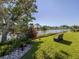 A tranquil backyard view of the lake with lush landscaping and mature trees at 1232 Pine Needle Rd, Venice, FL 34285