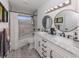 Updated bathroom featuring a double vanity with marble countertop, stylish mirrors, and modern fixtures at 1232 Pine Needle Rd, Venice, FL 34285