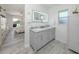 Bright bathroom featuring a double vanity with marble countertop and illuminated mirror, seamlessly connected to the main bedroom at 1232 Pine Needle Rd, Venice, FL 34285