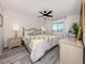 Comfortable bedroom featuring light grey wood flooring, a ceiling fan, and stylish decor, offering a cozy retreat at 1232 Pine Needle Rd, Venice, FL 34285