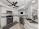 Modern kitchen featuring stainless steel appliances, granite countertops, and white cabinets at 1232 Pine Needle Rd, Venice, FL 34285