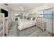 Bright main bedroom with white furnishings and a ceiling fan, featuring a sliding glass door to the outdoor patio at 1232 Pine Needle Rd, Venice, FL 34285