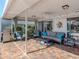 A covered patio offers space for relaxation and outdoor entertainment with a fan and soft seating at 1232 Pine Needle Rd, Venice, FL 34285