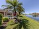 Scenic backyard view of waterfront property with tropical foliage and screened-in lanai at 13166 Huerta St, Venice, FL 34293