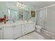 Bright bathroom featuring a double sink vanity with white cabinets and a glass-enclosed shower at 13166 Huerta St, Venice, FL 34293