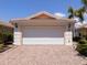 Two-car garage with brick driveway, lush landscaping, and a well-maintained exterior at 13166 Huerta St, Venice, FL 34293