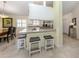 The kitchen has a bar-height countertop with stools, stainless steel appliances, and white cabinetry at 13166 Huerta St, Venice, FL 34293