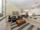A open concept living room with a coffee table, green sofa and eat-in kitchen with bar seating at 13166 Huerta St, Venice, FL 34293