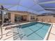 Relaxing pool area featuring a clear blue swimming pool, steps, and nearby outdoor furniture at 13166 Huerta St, Venice, FL 34293