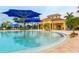 Relaxing community pool featuring plentiful seating, shaded umbrellas, and a charming clubhouse in the background at 13166 Huerta St, Venice, FL 34293