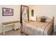 Comfortable bedroom featuring a decorative painting, desk, and bedside table with a lamp at 13415 Coluccio St, Venice, FL 34293