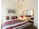 Well-lit bedroom features a striped bedspread, white furnishings and a large mirror at 13415 Coluccio St, Venice, FL 34293