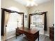 A well-lit office space with a traditional wood desk, comfortable chair, and elegant window treatments at 13415 Coluccio St, Venice, FL 34293