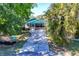Charming cottage exterior with screened-in porch, driveway and lush tropical landscaping at 140 Avenida De La Isla, Nokomis, FL 34275