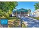 Charming cottage exterior with screened-in porch, and lush landscaping at 140 Avenida De La Isla, Nokomis, FL 34275