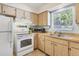 Efficient kitchen layout with wood cabinets, modern appliances, and natural light at 140 Avenida De La Isla, Nokomis, FL 34275