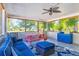 Inviting screened porch with comfortable seating, ceiling fan, and stylish decor at 140 Avenida De La Isla, Nokomis, FL 34275