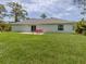 Backyard view showing patio, outdoor furniture, and green lawn at 15232 Faulkner Ave, Port Charlotte, FL 33953
