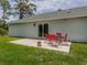Outdoor patio with a dining table and chairs overlooking a spacious green yard at 15232 Faulkner Ave, Port Charlotte, FL 33953