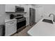 Galley kitchen features stainless appliances, stone countertops, and white shaker cabinets at 15232 Faulkner Ave, Port Charlotte, FL 33953