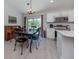 Bright eat-in kitchen features a dark wood dining table, stainless appliances, and backyard access at 15232 Faulkner Ave, Port Charlotte, FL 33953
