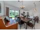 Bright eat-in kitchen features a dark wood dining table, stainless appliances, and backyard access at 15232 Faulkner Ave, Port Charlotte, FL 33953