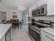 Kitchen features stainless appliances, stone countertops, dining area with slider to backyard at 15232 Faulkner Ave, Port Charlotte, FL 33953