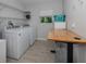 Laundry room features appliances, storage shelves, and a folding table at 15232 Faulkner Ave, Port Charlotte, FL 33953