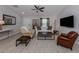 Bright living room featuring neutral walls, tile floors, modern furniture, and large TV at 15232 Faulkner Ave, Port Charlotte, FL 33953