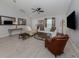 Bright living room featuring neutral walls, tile floors, modern furniture, and large TV at 15232 Faulkner Ave, Port Charlotte, FL 33953