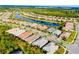 Aerial view of a residential community featuring homes, a serene lake, and lush green landscaping at 1565 Hyssop Loop, North Port, FL 34289