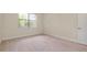 Spacious carpeted bedroom featuring a window and a door adding to the room's inviting charm at 1565 Hyssop Loop, North Port, FL 34289