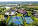 Aerial view showcases tennis courts, pools, clubhouse, and beautiful green landscaping of the community at 1565 Hyssop Loop, North Port, FL 34289