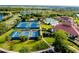 Aerial view of community amenities, including tennis courts, pools, clubhouse, and surrounding landscape at 1565 Hyssop Loop, North Port, FL 34289