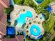 Aerial view of community pools surrounded by palm trees, lounge chairs, and lush landscaping at 1565 Hyssop Loop, North Port, FL 34289