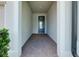 Covered entryway featuring brick pavers and a stylish front door at 1565 Hyssop Loop, North Port, FL 34289