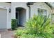 Inviting front entrance featuring brick pavers, tropical plants, and a covered archway at 1565 Hyssop Loop, North Port, FL 34289