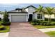 Charming single-Gathering home featuring a brick driveway, attached garage, and well-manicured landscaping at 1565 Hyssop Loop, North Port, FL 34289