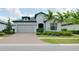 Inviting single-story home with a brick driveway, well-maintained landscaping, and a neutral color scheme at 1565 Hyssop Loop, North Port, FL 34289